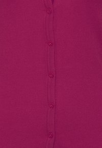 Dopasowany kardigan z dzianiny w intensywnym odcieniu magenty, z zapinanym na pięć pasujących guzików przodem oraz prążkowaną fakturą na krawędziach.