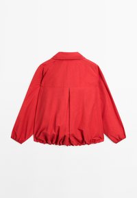 Veste rouge avec col, pli dans le dos et ourlet élastiqué. Fabriquée en tissu lisse, elle possède des manches longues et une coupe décontractée.