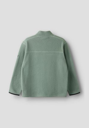 Veste polaire vert menthe vue de dos avec un col montant et une bordure noire aux poignets des manches.