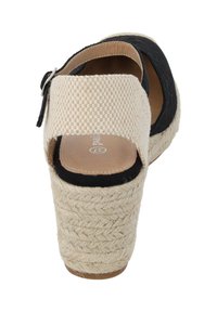 Sandales à talon compensé noires et beiges avec un talon en jute tressé, bout ouvert et bride de cheville. Tissu noir texturé et empeigne à carreaux beiges.