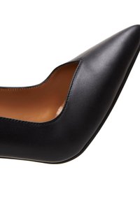 Escarpin en cuir noir avec un bout pointu et un design découpé. Texture lisse et doublure intérieure marron. Style minimaliste, sans matériel visible.