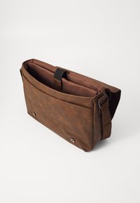 Sac messager en cuir marron avec une finition texturée, une poche intérieure, une sangle réglable et des détails métalliques à pression à la base.