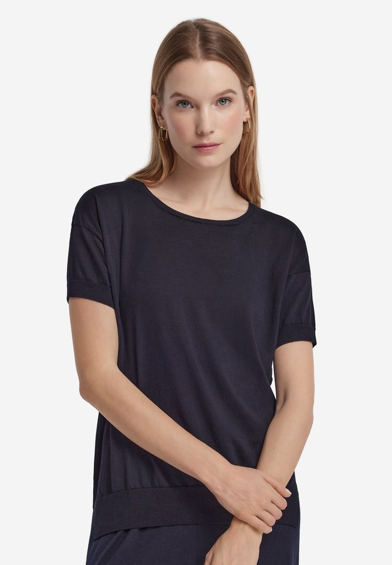 Granatowy t-shirt z krótkim rękawem wykonany z miękkiego materiału, z okrągłym dekoltem i prążkowanymi wykończeniami na mankietach rękawów oraz na dolnym brzegu.