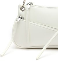 Weißes Lederhandtasche mit einer schlanken, geschwungenen Form. Verfügt über silberne Reißverschlüsse, zwei schmale Griffe und sichtbare Nähte auf der Oberfläche.