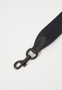 Navy nylon strap with leather accents, featuring a bronze metal clip and stitching detail. The strap is flat and wide for comfortable use.