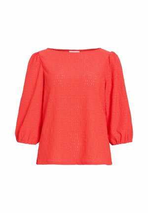 Svijetloružičasta bluza od tkanine s otvorima, s tričetvrt rukavima na naduvavanje i širokim okruglim izrezom na vratu.