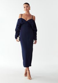 Tmavě modré šaty s dlouhými rukávy a designem bez ramínek, včetně nařaseného živůtku a štíhlého siluetu až na podlahu.