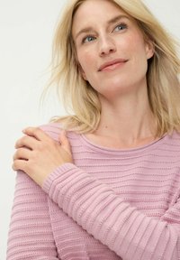 Hellrosa gestricktes Langarmshirt mit horizontaler Rippenstruktur, rundem Ausschnitt und enganliegenden Bündchen. Dezente Variationen im Strickmuster.