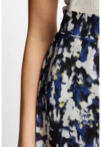 Falda de estampado floral en tonos de negro, azul y amarillo, fabricada con un tejido ligero y de textura suave, con cintura ajustada.