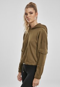 Sudadera verde oliva con cintura ajustable, mangas largas y dos bolsillos laterales. Textura suave, corte casual y puños ajustados.