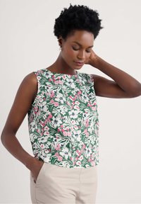 Cvetna brezrokavna majica v zeleni barvi, ki ima roza in belo cvetje, okroglo vratno odprtino in sproščen kroj, izdelana iz lahkotnega materiala.
