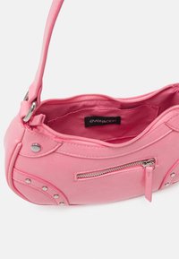 Borsa a spalla in similpelle rosa con una forma curva e strutturata. Presenta dettagli in metallo argentato, una tasca con cerniera e una morbida fodera.