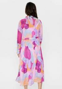 Lungo abito trasparente in colori pastello, con motivi astratti di rosa, viola e arancione. Include maniche con bottoni e una cintura annodata in vita.