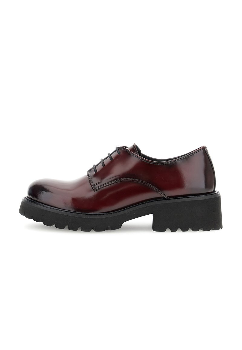Scarpa stringata in pelle rossa scura con suola a cuscinetto nera spessa e tacco chunky, vista dal lato esterno su sfondo bianco.