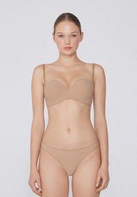 Nude bezšvová podprsenka a odpovídající bikiny, s nastavitelnými ramínky, hladkým povrchem a tvarovanou siluetou pro bezpečné nošení.