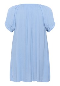 Blouse bleu clair à manches courtes avec une coupe décontractée. Présente des fronces et un tissu doux et texturé. Détail de boutons sur les manches enroulées.