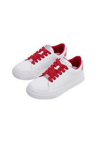 Weiße sportliche Sneakers mit roten Schnürsenkeln, einer Gummisohle und silbernen Logoakzenten. Sie verfügen über eine glatte Oberfläche und ein rundes Fußdesign.
