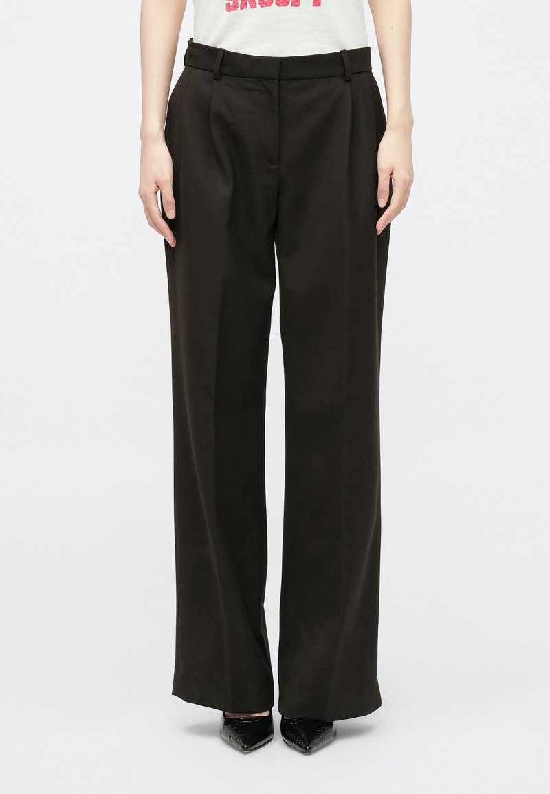 Hlače širokih nogavica od tamnosmeđe tkanine, s visokim pojasom s petljama za remen, prednjim nabranjima i glatkom teksturom.