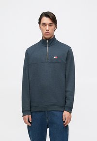 Sweatshirt de meia-cremona cinza escuro em mistura de algodão, apresentando uma costura horizontal, patch de logótipo em vermelho, branco e azul, e punhos canelados.