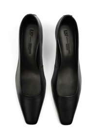 Ballerine in pelle nera con una superficie liscia, design con punta quadrata e stile slip-on. L'interno presenta un branding minimale.