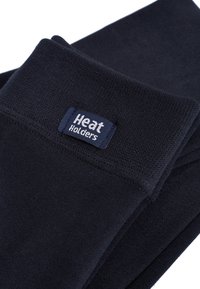 Crne termo čarape s mekanom teksturom i širokim rubom; sadrže plavu i bijelu oznaku "Heat Holders" ušivenu na rubu.