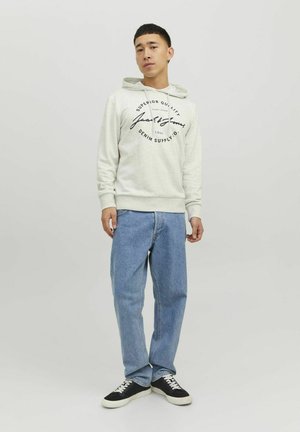 Light gray hoodie with a black printed logo, paired with light blue jeans and black shoes, featuring a casual, relaxed fit and fleece texture.