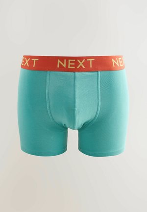 Boxeri aqua blue din bumbac moale, cu o talie roșie pe care scrie "NEXT" în litere aurii. Design ajustat cu o textură netedă.