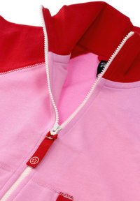 Hoodie w blokach kolorystycznych z czerwonym kołnierzykiem, różowym body i białym zamkiem błyskawicznym z czerwonym uchwytem. Wykonany z miękkiego bawełnianego materiału z kontrastującymi teksturami.