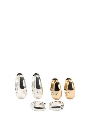 Trzy pary błyszczących kolczyków kołowych w odcieniach srebra i złota, prezentowane w pozycji stojącej i leżącej na białym tle.