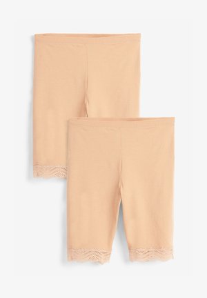 Beige legging gemaakt van zachte stof, met een decoratieve kanten rand aan de onderzoom met een gegolfd patroon.