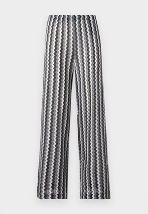 Μαύρο και άσπρο παντελόνι με φαρδιά μπατζάκια και ζιγκ-ζαγκ σχέδιο, με ψηλή μέση, το οποίο είναι απλωμένο σε λευκό φόντο.