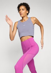 Világosszürke, cropped tank top és magas derekú rózsaszín leggings, sima textúrával és színkontraszttal, amely alkalmas sportos viseletre.