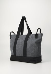 Graue Stofftasche mit schwarzen Akzenten, ausgestattet mit zwei stabilen schwarzen Griffen und einer strukturierten Oberfläche. Entworfen für Langlebigkeit und Praktikabilität.
