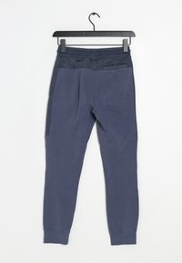 Marina blå joggers med en strukturerad mörk midjeband, avsmalnande ben, sidofickor och ribbade manschetter. Tillverkade av en mjuk tygblandning.