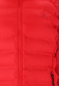 Rode pufferjack met een voorkant rits, horizontaal gestikt design en logo aan de linkerkant. Inclusief elastische koord aan de onderrand.