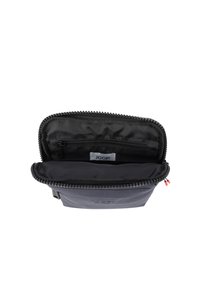 Mała granatowa saszetka na suwak, otwarta, ukazująca czarne wnętrze z wewnętrzną kieszonką na zamek i widoczną etykietą "JOOP!".