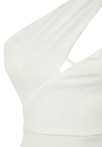 Robe blanche avec un design croisé et une ouverture découpée, confectionnée dans un tissu lisse. L'encolure est drapée et asymétrique.