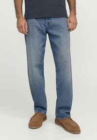 Helle blaue Jeans aus Denim, mit einem geraden Bein Design, verblasstem Finish und klassischem Fünf-Taschen-Stil, kombiniert mit braunen Mokassins.