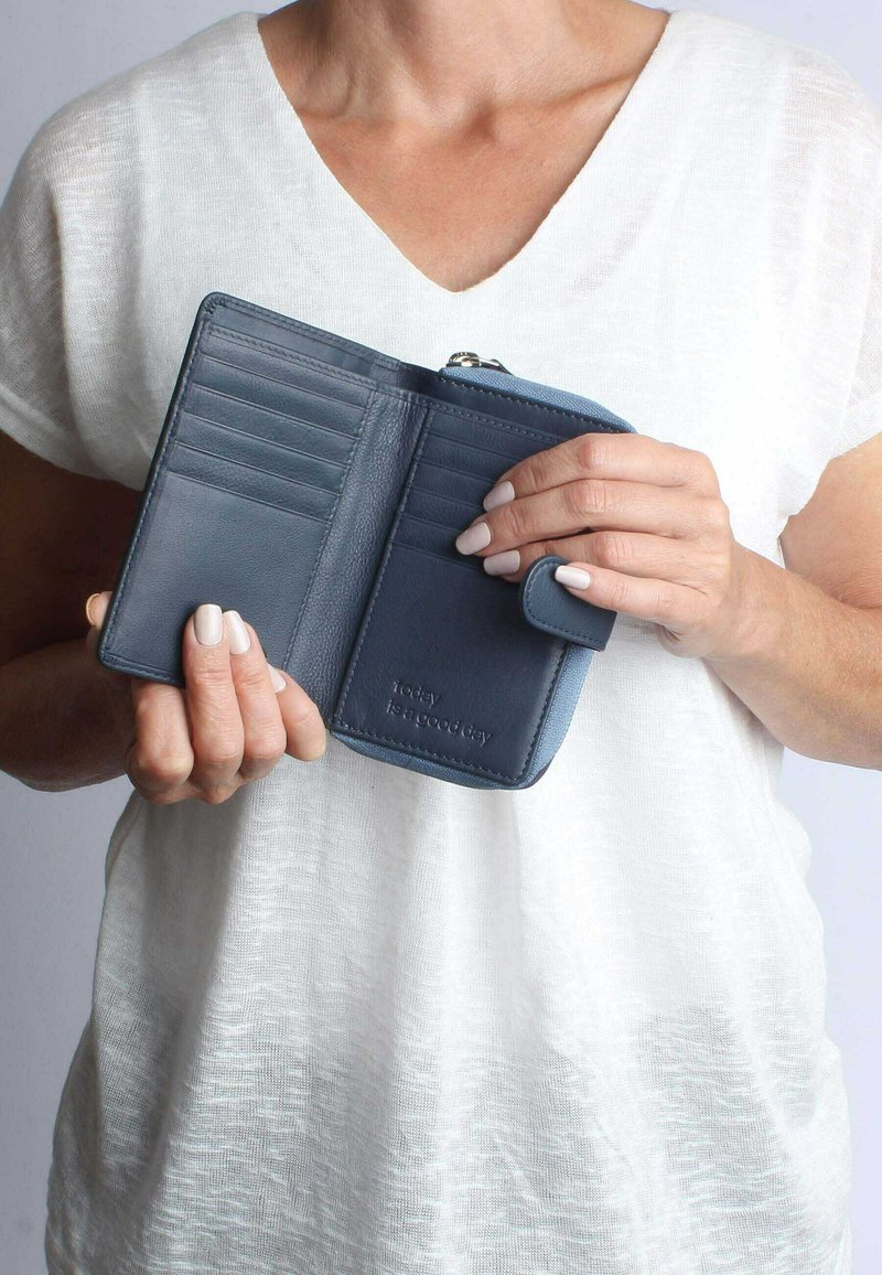 Portafoglio in pelle blu con diversi scomparti per carte, un comparto con zip e una chiusura a scatto. Testo impresso che recita "oggi è una bella giornata".