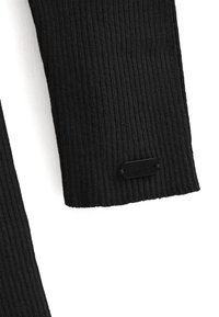 Svart stickad tröja med ribbat tyg och en strukturerad mönster; har en svart Polo Club-logotyp sydd vid fållen.