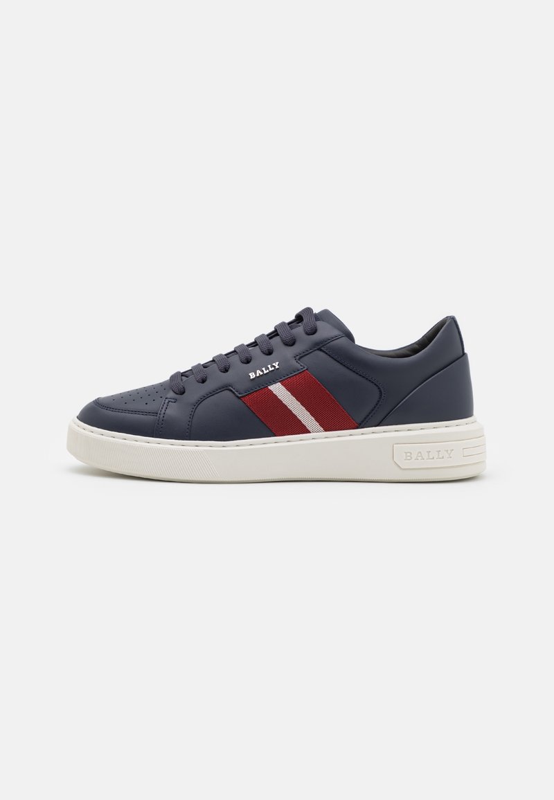 Baskets en cuir bleu foncé avec bandes latérales rouges et blanches, semelle blanche, lacets à l'avant et marquage "BALLY" sur le côté et la semelle.