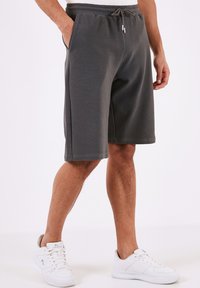 Grå, ribbede athletic shorts med elastisk talje og justerbar snøre. Side lommer og et løst fit design.