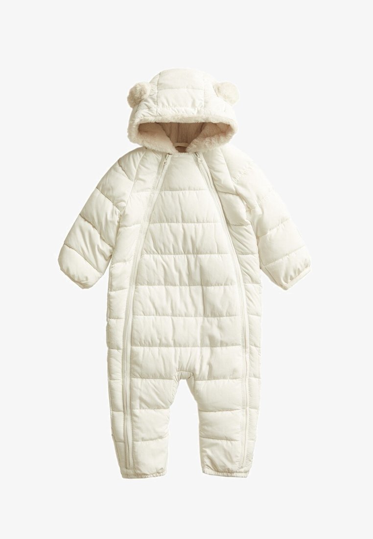 Padded all-in-one suit in cream with a hood, featuring bear ear accents, zip closures, and quilted texture for warmth and comfort.