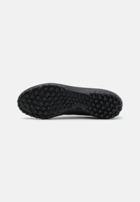 Black athletic shoe sole featuring a hexagonal textured pattern with prominent grip. Logo displayed on the side near the heel.