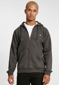Sivi zip-up dukserica s kangaroo džepom, kapuljačom sa vrpcom, rebrastim manžetama i malim logotipom na grudima. Materijal od mješavine pamuka.