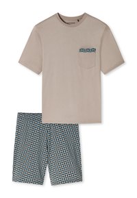 Beige t-paita, jossa on lyhyet hihat ja kuvioitu tasku, yhdistettynä kuvioituihin sinisiin shortsseihin, joissa on geometrinen design vaaleassa kermassa.