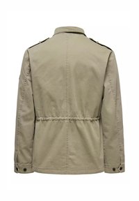 Giacca khaki con vita cintrata, maniche lunghe e spalline. Realizzata in un tessuto leggero con una texture liscia.