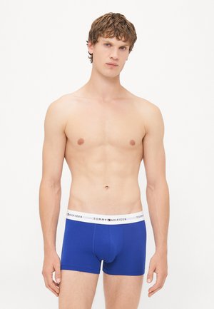 Blaue Boxer-Briefs aus Baumwolle mit einem weißen Bund, der das Logo "TOMMY HILFIGER" trägt. Glatte Textur und enganliegendes Design.