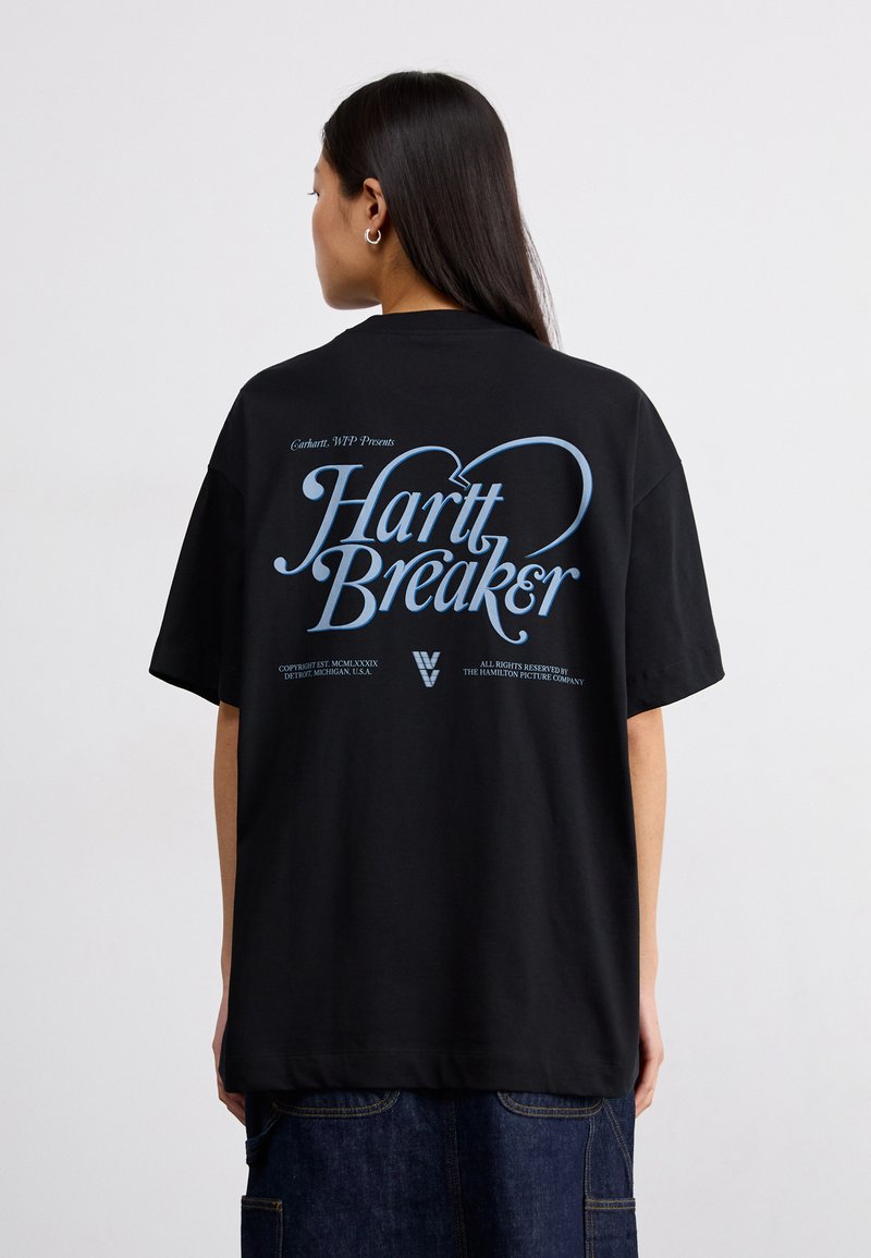 Camiseta de algodón negra con grandes gráficos azules en la parte posterior que dicen "Hart Breaker". El diseño incluye mangas cortas y un corte holgado.