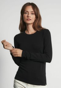 Czarny sweter z długim rękawem wykonany z miękkiego materiału, z okrągłym dekoltem i dekoracyjnymi guzikami na ramieniu. Dopasowany krój.